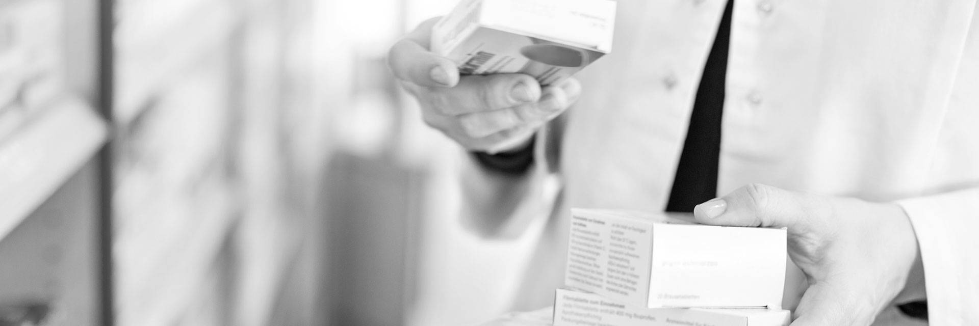 Doctor reading package information on a prescription